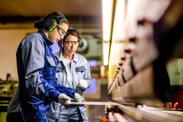 Two industrial workers operating workshop machinery